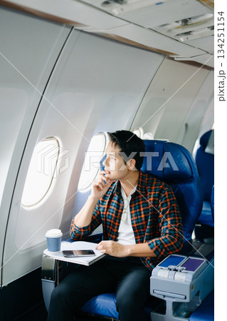 Travel stress, jet lag, or motion sickness. Young man with a headache or fatigue during a long flight. Tired passenger on a business trip. Pain, sit, air, mobile. 134251154