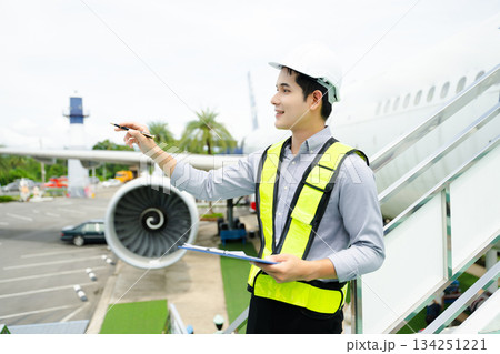 Aviation engineer inspects airplane for safety compliance. Professional aerospace technician at work in airport maintenance Aviation engineer inspects airplane for safety compliance. Professional aerospace technician at work in airport maintenance 134251221