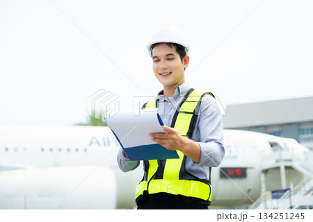 Aviation engineer inspects airplane for safety compliance. Professional aerospace technician at work in airport maintenance Aviation engineer inspects airplane for safety compliance. Professional aerospace technician at work in airport maintenance 134251245