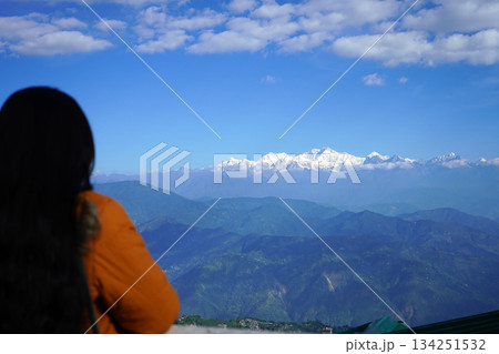 Young woman looking at snowcapped Himalayan mountain peaks from a scenic viewpoint Young woman looking at snowcapped Himalayan mountain peaks from a scenic viewpoint 134251532