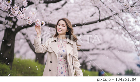 桜並木の川岸を歩く若い日本人女性のポートレート 134251584
