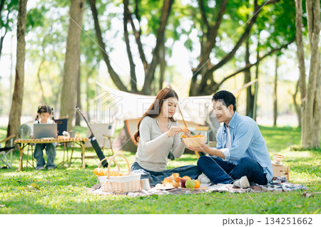 Asian couple enjoys a peaceful camping morning with coffee, breakfast, music, and devices in nature Asian couple enjoys a peaceful camping morning with coffee, breakfast, music, and devices in nature 134251662