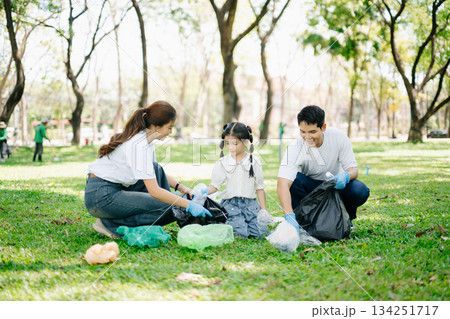 Asian parents and child collect bottles at the park, sharing love, teamwork, and care. A green lifestyle moment promoting recycling, unity 134251717