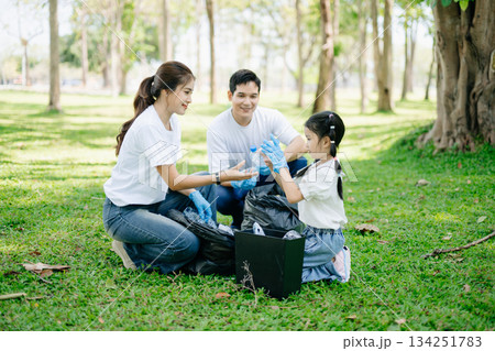 Asian parents and child collect trash in the forest, promoting recycling, unity, and ecology. A heartwarming scene of love, care, teamwork Asian parents and child collect trash in the forest, promoting recycling, unity, and ecology. A heartwarming scene of love, care, teamwork 134251783