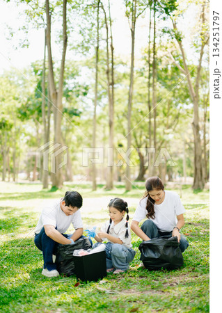 Asian parents and child collect trash in the forest, promoting recycling, unity, and ecology. A heartwarming scene of love, care, teamwork Asian parents and child collect trash in the forest, promoting recycling, unity, and ecology. A heartwarming scene of love, care, teamwork 134251797