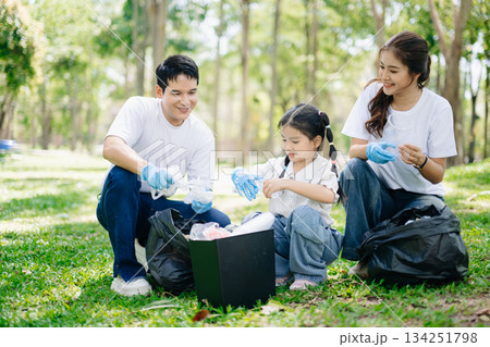 Asian parents and child collect bottles at the park, sharing love, teamwork, and care. A green lifestyle moment promoting recycling, unity Asian parents and child collect bottles at the park, sharing love, teamwork, and care. A green lifestyle moment promoting recycling, unity 134251798