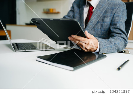Businessman hand using smart phone laptop and tablet with social network diagram on desk as concep 134251857