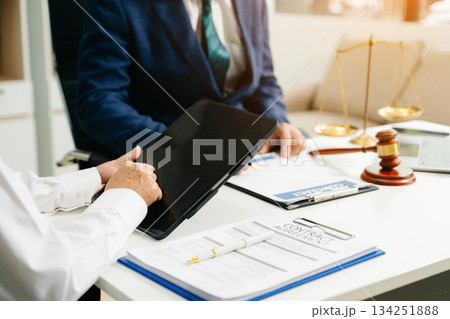 Business and lawyers discussing contract papers with brass scale on desk in office. Law, legal services, advice Business and lawyers discussing contract papers with brass scale on desk in office. Law, legal services, advice 134251888