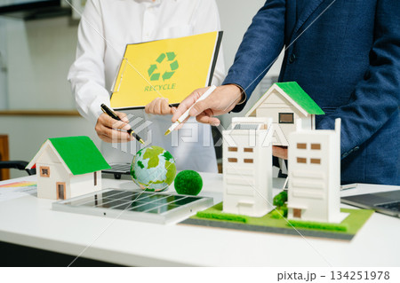 Engineers discuss solar panels and turbines in office, working on clean energy design, sustainable power Engineers discuss solar panels and turbines in office, working on clean energy design, sustainable power 134251978