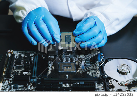 The technician is putting the CPU on the socket of the computer motherboard. electronic engineering electronic The technician is putting the CPU on the socket of the computer motherboard. electronic engineering electronic 134252032