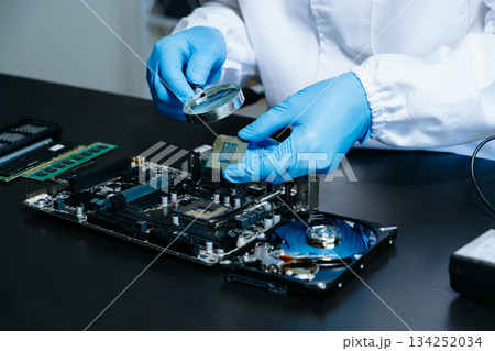 The technician is putting the CPU on the socket of the computer motherboard. electronic engineering electronic 134252034