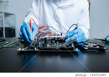 Electronics technician, electronic engineering electronic repair, electronics measuring and testing, repair and maintenance concepts.uses a voltage meter to check 134252043