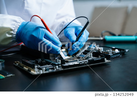 The technician is putting the CPU on the socket of the computer motherboard. electronic engineering electronic 134252049