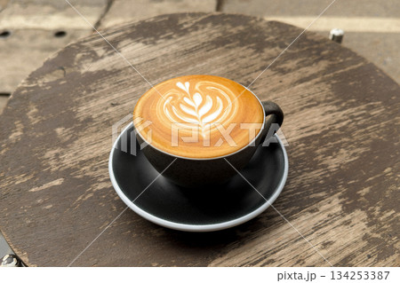Hot coffee, a hot latte in a mug on a wooden table. 134253387