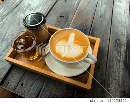 Hot coffee. Holding a hot latte in a mug from the cafe. 134253391