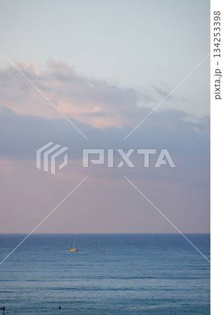 夕暮れの広い海に浮かぶ黄色いヨット, ワイキキ沖 夕暮れの広い海に浮かぶ黄色いヨット, ワイキキ沖 134253398