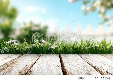 Spring background with fresh grass and white wooden table. Spring apple garden on the background Spring background with fresh grass and white wooden table. Spring apple garden on the background 134253408