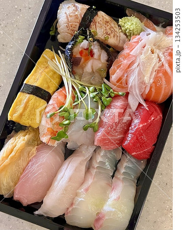 An assortment of fresh sushi, artfully arranged with a variety of toppings and vibrant colors. This traditional Japanese dish combines vinegared rice, seafood, and vegetables for an experience. 134253503