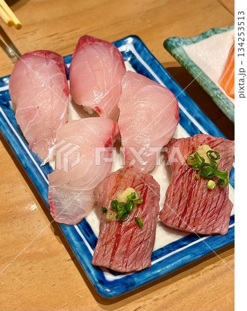 Fresh tuna sushi with vibrant red slices of tender fish atop perfectly shaped white rice, showcasing smooth texture, rich color, and delicate detail in close-up view Fresh tuna sushi with vibrant red slices of tender fish atop perfectly shaped white rice, showcasing smooth texture, rich color, and delicate detail in close-up view 134253513