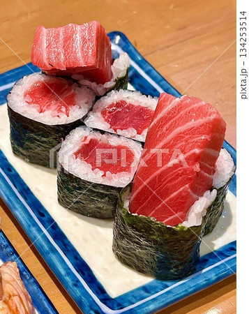 Fresh tuna sushi with vibrant red slices of tender fish atop perfectly shaped white rice, showcasing smooth texture, rich color, and delicate detail in close-up view Fresh tuna sushi with vibrant red slices of tender fish atop perfectly shaped white rice, showcasing smooth texture, rich color, and delicate detail in close-up view 134253514