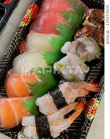 An assortment of fresh sushi, artfully arranged with a variety of toppings and vibrant colors. This traditional Japanese dish combines vinegared rice, seafood, and vegetables for an experience. 134253835