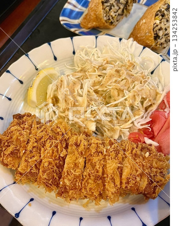 Crispy tonkatsu, a Japanese-style breaded and deep-fried pork cutlet, served with shredded cabbage and drizzled with savory sauce. A delightful balance of crunchy texture and juicy meat. Crispy tonkatsu, a Japanese-style breaded and deep-fried pork cutlet, served with shredded cabbage and drizzled with savory sauce. A delightful balance of crunchy texture and juicy meat. 134253842