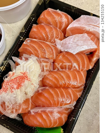 Fresh salmon sushi with bright orange slices placed on top of perfectly shaped rice, garnished with green leaves and radish for a simple, colorful, and appetizing presentation Fresh salmon sushi with bright orange slices placed on top of perfectly shaped rice, garnished with green leaves and radish for a simple, colorful, and appetizing presentation 134255150