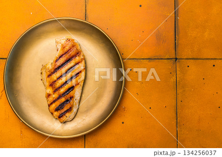 Grilled Chicken breast steak on a plate, fried poultry meat, top view. Grilled Chicken breast steak on a plate, fried poultry meat, top view. 134256037