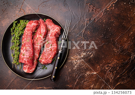 Tri tip steaks, Raw marbled beef meat on plate with herbs. brown background. top view Tri tip steaks, Raw marbled beef meat on plate with herbs. brown background. top view 134256073