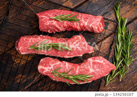 Raw Tri Tip Steak from Black Angus beef meat with rosemary. wooden background. top view Raw Tri Tip Steak from Black Angus beef meat with rosemary. wooden background. top view 134256107