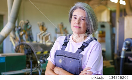 Senior woman worker crossing arms in factory workshop 134256205