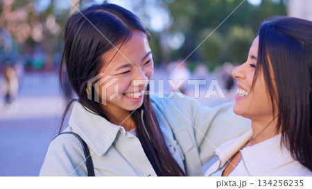 Diverse women friends smiling, embracing outdoors, showing inclusion Diverse women friends smiling, embracing outdoors, showing inclusion 134256235