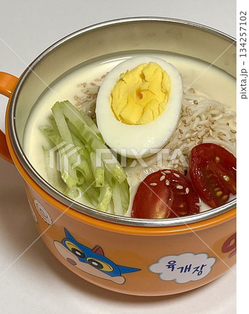 Kungguksu, a savory Korean cold noodle dish served in a rich broth, topped with fresh vegetables and garnished with seaweed. Perfect for summer meals, capturing the essence of Korean comfort food. Kungguksu, a savory Korean cold noodle dish served in a rich broth, topped with fresh vegetables and garnished with seaweed. Perfect for summer meals, capturing the essence of Korean comfort food. 134257102