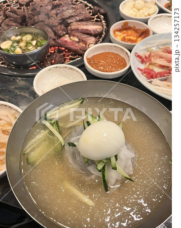 Authentic Pyongyang naengmyeon with chewy buckwheat noodles in cold, clear broth, offering a refreshing and delicate flavor. Perfect for traditional Korean cuisine menus and summer dishes. Authentic Pyongyang naengmyeon with chewy buckwheat noodles in cold, clear broth, offering a refreshing and delicate flavor. Perfect for traditional Korean cuisine menus and summer dishes. 134257173
