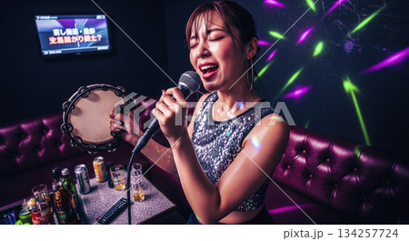 一人カラオケではしゃぐ女性 134257724