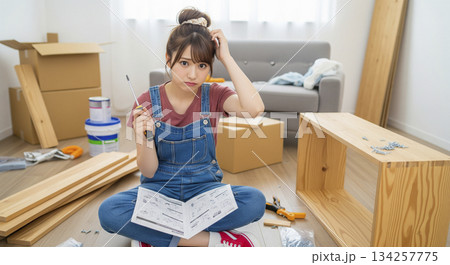 組み立て家具を説明書を見ながら奮闘している女性 DIY 134257775