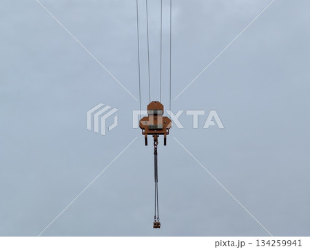 minimalist construction equipment depiction, suspended crane hook with cable in overcast outdoor minimalist construction equipment depiction, suspended crane hook with cable in overcast outdoor 134259941