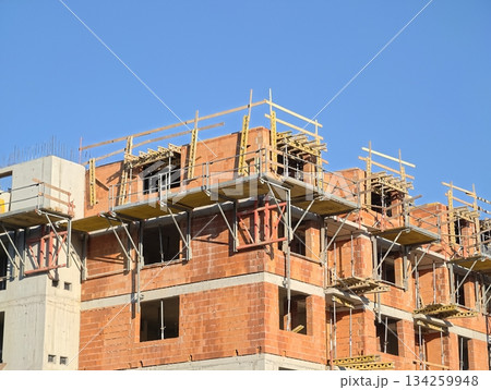 construction progress documented, building progress captured with scaffolding and insulation details 134259948