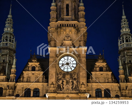 lighting accentuates historic civic structure, ancient clock tower illuminated amid evening sky lighting accentuates historic civic structure, ancient clock tower illuminated amid evening sky 134259953