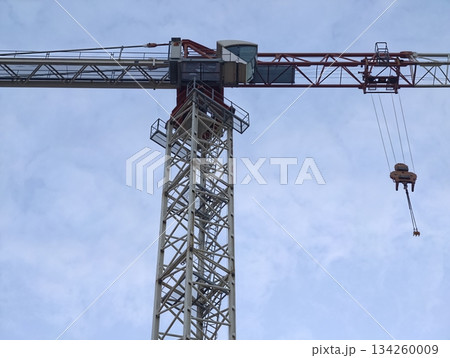 crane silhouette scene, highrise construction crane with cab and cable tension amid cloudy sky crane silhouette scene, highrise construction crane with cab and cable tension amid cloudy sky 134260009