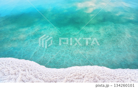 Shore of Dead sea in Ein Bokek, Israel, white salt crystals outside and at the bottom, turquoise clear water Shore of Dead sea in Ein Bokek, Israel, white salt crystals outside and at the bottom, turquoise clear water 134260101