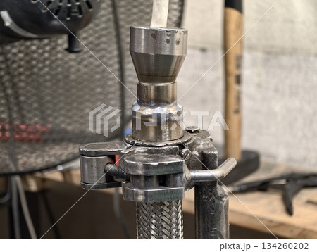 workshop scene of plumbing installation, closeup of plumber preparing metal fitting for leak testing 134260202