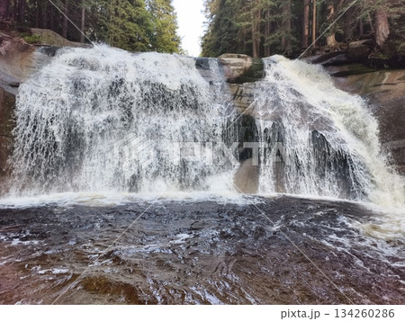 flowing water shapes tranquil natural scene, juxtaposition of energetic waterfall and serene pond environment 134260286
