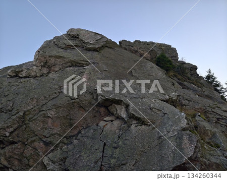 challenging rocky peak reaching skyward, summit cliff with jagged rocks and exposed surfaces 134260344