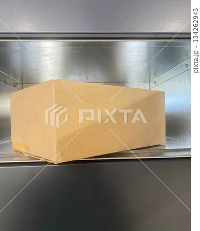 Open Gray Parcel locker with Cardboard box inside. Open Gray Parcel locker with Cardboard box inside. 134262943