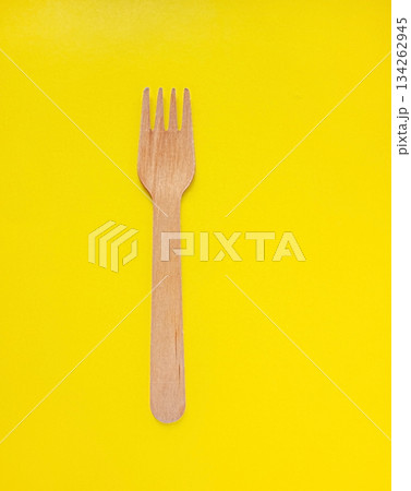 Organic bamboo disposable fork on yellow background. Environmentally friendly wooden fork. Ecology, zero waste concept with copy space. Organic bamboo disposable fork on yellow background. Environmentally friendly wooden fork. Ecology, zero waste concept with copy space. 134262945