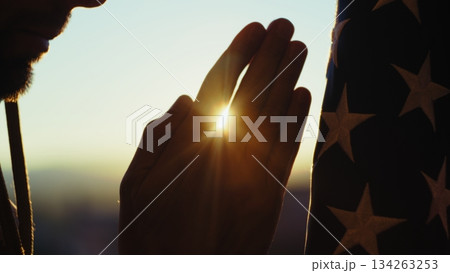 Hands Joined in Prayer of a Soldier in Front of the American Flag Silhouette 134263253