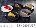 Assorted Cake Slices On Dark Slate Plates Create Colorful Dessert Display For Party 134264157