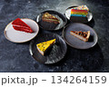 Assorted Cake Slices On Dark Slate Plates Create Colorful Dessert Display For Party 134264159