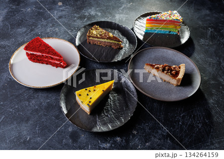 Assorted Cake Slices On Dark Slate Plates Create Colorful Dessert Display For Party Assorted Cake Slices On Dark Slate Plates Create Colorful Dessert Display For Party 134264159